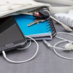 Wysoki kąt widoku smartfona z książkami w torebce na stole