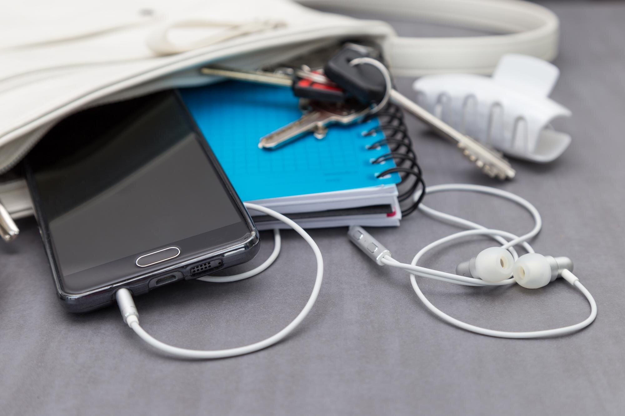 Wysoki kąt widoku smartfona z książkami w torebce na stole