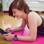 Dysponowana kobieta używa pastylka komputer osobistego na macie