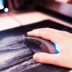 Mysz komputerowa z ludzką ręką na podkładce pod mysz bokeh w tle hd