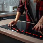 Kobieta włącza piec indukcyjną w kuchni.