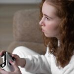 Portret nastolatki Generacji Z grającej w domu na konsoli w grę wideo