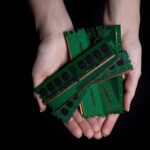 Kobiece ręce trzymają kartę pamięci komputera, amerykańską kobietę noszącą mundur naukowca, trzymającą mikroczip procesora w laboratorium