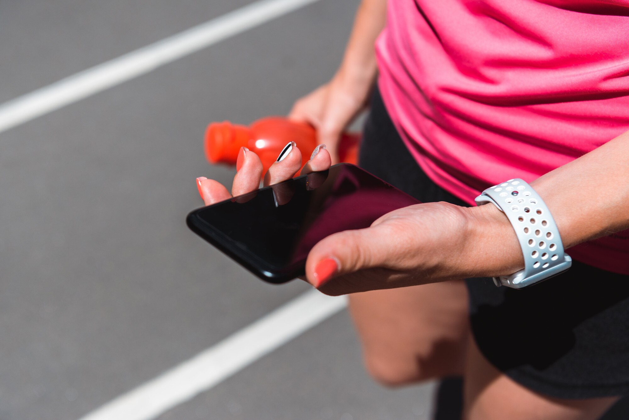 Sportsmenka patrzeje smartphone podczas gdy jogging na bieg śladzie